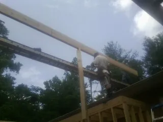 Carpenter setting a ridge beam over a new addition frame — Ice Dam Removal by Roofing Brothers in Elk Mountain