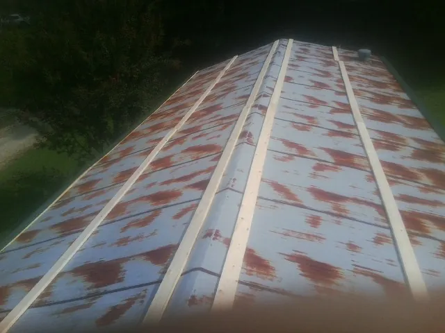 Rusted metal roof panels with new wood purlins before replacement — Storm Damage Roof Repair in Elk Mountain by Roofing Brothers