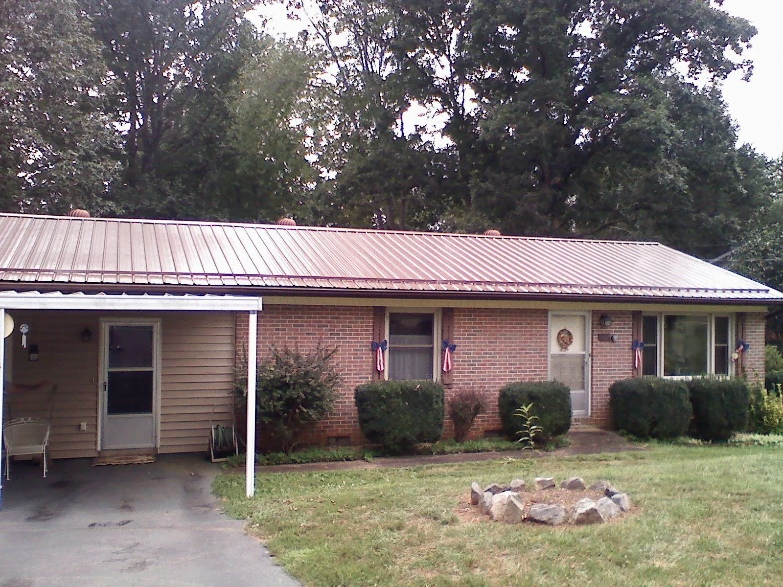 Bronze metal roof and carport on a brick ranch home — Roof Repair work by our crew in Elk Mountain